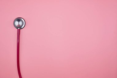 Pembe arka planda pembe bir steteskop.