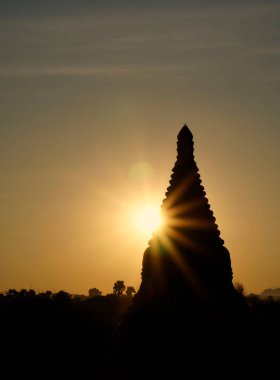 Gün doğumunda güneş ışınlı Bagan tapınağının silueti.