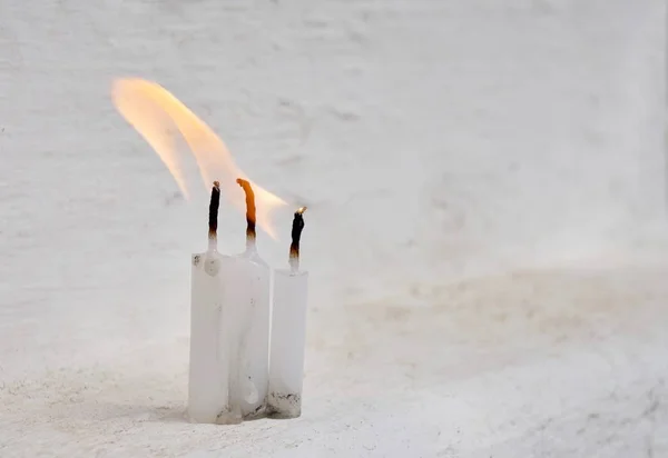 Tres velas blancas con llama en el fondo blanco sucio — Foto de Stock