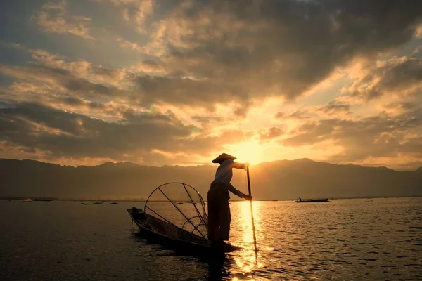 En fiskare med en koja seglar en båt på Inle sjön på morgonen, Myanmar — Stockfoto