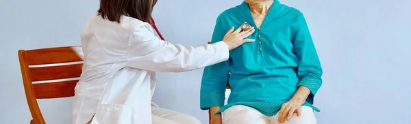Жінка-лікар використовує стетоскоп, щоб слухати легені пацієнта, у якого захворювання легень — стокове фото