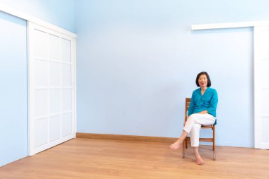An old beautiful asian woman with smiling face in blue blouse on the white background