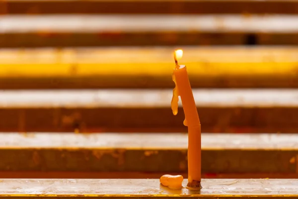 yellow bend candle with flame lighted from people in the Buddhis