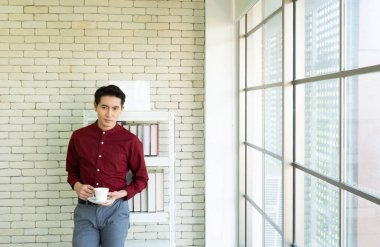 Kendine güveni olan yakışıklı Asyalı bir iş adamı. 