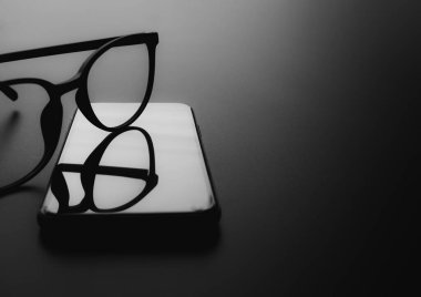 Siyah arka plandaki akıllı telefondaki gözlük.