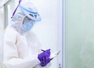 Kişisel koruyucu ekipmanlı bir doktor, hastanedeki kovid 19 hastalarını ziyaret ediyor.