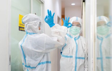 Kişisel koruyucu donanımlı iki doktor hastanede dirseğine dokunarak birbirlerini selamlıyorlar. covid-19, koronavirüs, sosyal uzaklık, izolasyon, karantina, tıbbi konsept