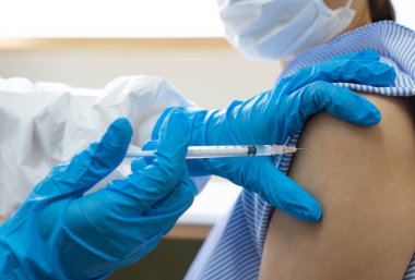 Eldiven giyen bir doktor aşıyı hastanedeki kadın hastaya enjekte ediyor. covid-19, koronavirüs, aşı, aşı, aşı, aşı, tıbbi, sağlık konsepti