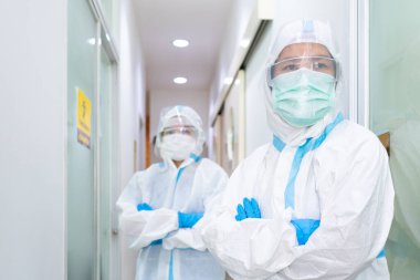 Beyaz takım elbise, maske, yüz kalkanı ve eldivenler de dahil olmak üzere iki doktor koronavirüs patenti tedavisi hakkında tartışıyorlar. covid-19, hastane, karantina birimi konsepti