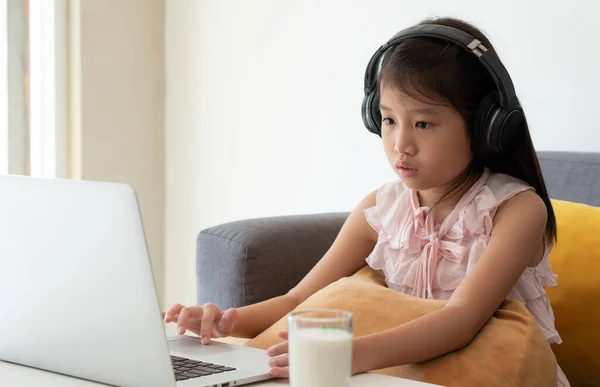 An asian girl is studying online course via computer as a home school student. social distancing, isolation, quarantine, covid-19, coronavirus, medical, technology, education concept