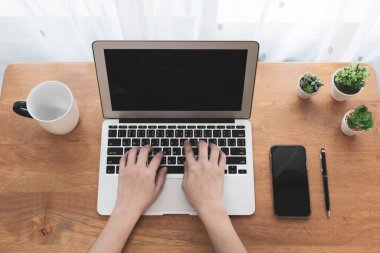 Oturma odasındaki masada çalışmak için bilgisayar kullanan bir kadın. Evden çalışma, sosyal uzaklık, izolasyon, covid-19, koronavirüs, serbest çalışma, iş, teknoloji konsepti