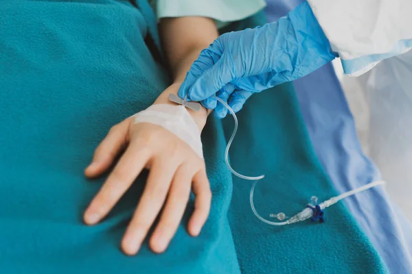 close up picture of doctor wearing gloves giving intravenous fluid to the critical patient with covid-19 or coronavirus infection. medical concept (fouus at doctor\'s hand)