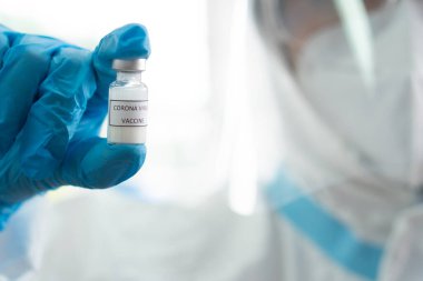 Kişisel koruyucu ekipman alanında çalışan bir doktor ya da hastane laboratuarında kovid 19 ya da koronavirüs aşısı gösteren bir doktor. aşılama ve aşılama kavramı