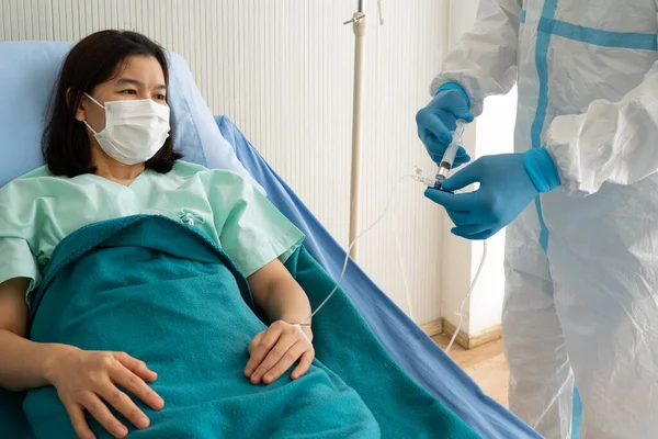 パンデミック時の病院の隔離室で アジアの女性患者をCovid 19またはコロナウイルス感染で治療する個人的な予防装置またはパイプの2人の医師 医療の概念 — ストック写真