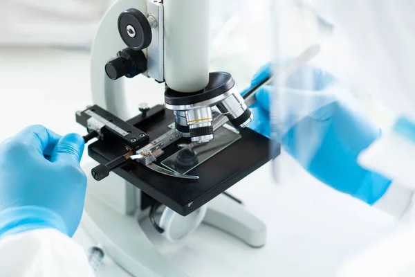 개인을 착용하고 과학자들의 현미경을 사용하는 장비나 조직을 이용하여 실험실에서의 코로나 — 스톡 사진