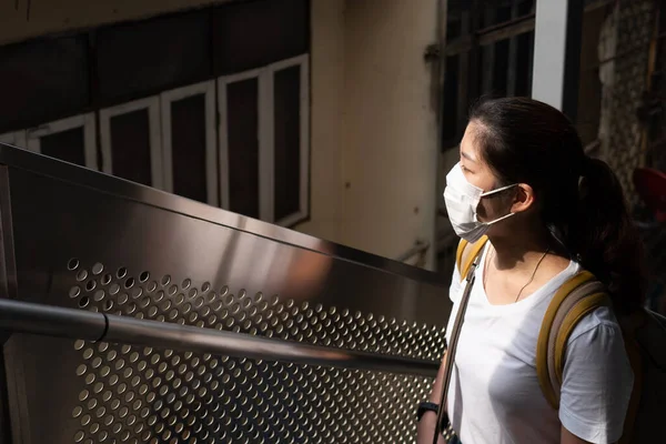 顔のマスカスを身に着けている若い美しいアジアの女性は 社会的距離のガイドライン 彼女はエスカレーターを使ってスカイトレインの駅に上がろうとしている 新しい正常な生活 Covid コロナウイルスの概念 — ストック写真