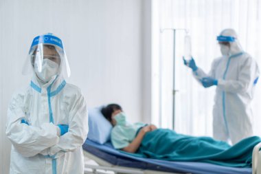 Asyalı doktor ve hemşire kişisel koruyucu ekipman takıyor ya da hastanede kovid 19 veya koronavirüs enfeksiyonu olan hastayı tedavi etmek için Pppe kullanıyor. Sağlık ve Tıp Konsepti