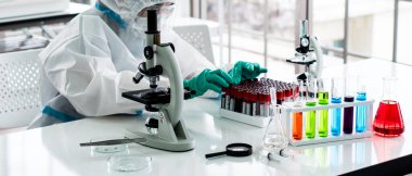 Kişisel koruma ekipmanları içinde bilim adamının flaş resmi veya laboratuvarda covid-19 veya coronavirus enfeksiyonunu tedavi edecek ilaçlar bulmak için araştırma ve deney yapan