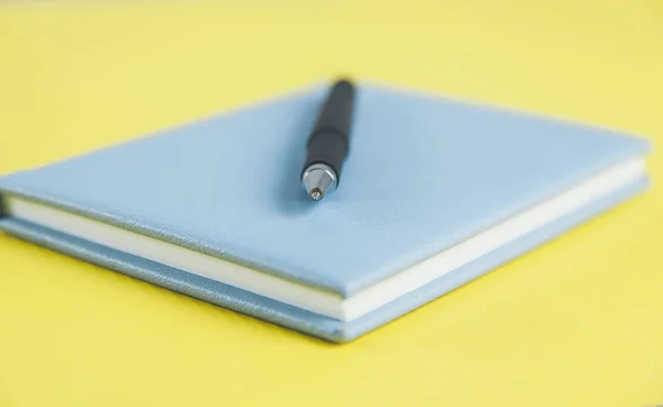 青いメモ帳にペンを — ストック写真