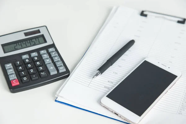 Telefon mit Taschenrechner im Dokument — Stockfoto