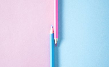 Masa arkasında pembe ve mavi kağıtlar ve kalemler