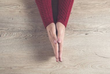 Dua eden kadın elleri ahşap masanın üstünde.