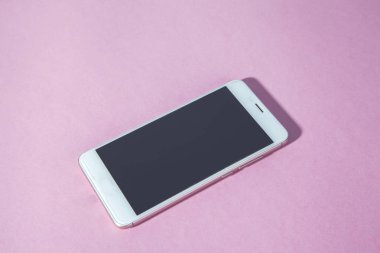 Pembe masa arkasındaki akıllı telefon.