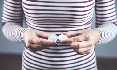 Kadın arka planda lensleri tutuyor.