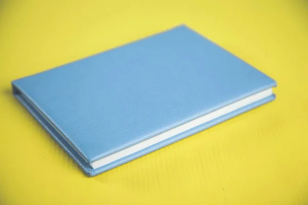 Blue Notepad Yellow Desk Background — Stock Photo, Image