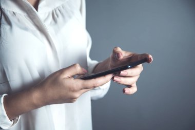 İş kadını Gri arka planda akıllı telefon