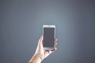 Gri duvar arkaplanındaki akıllı telefon.