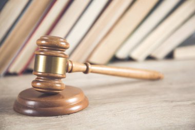 Masanın üzerinde kitap geçmişi olan ahşap yargıç.