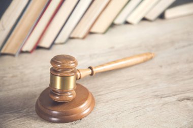 Masanın üzerinde kitap geçmişi olan ahşap yargıç.