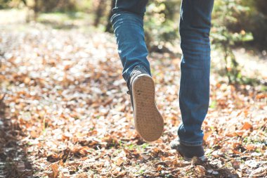 İnsan doğada sonbahar ormanlarında koşar.