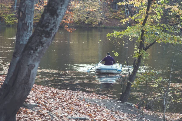Gölü ve sonbahar ormanı olan teknedeki insanlar