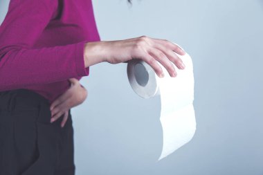 Gri arka planda kadın eli tuvalet kağıdı