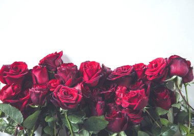 Beyaz masa arkasında kırmızı güller.