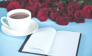 Kahveli ve not defterli kırmızı güller.