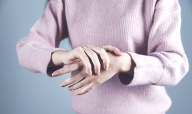 Gri arka planda el ele tutuşan kadın