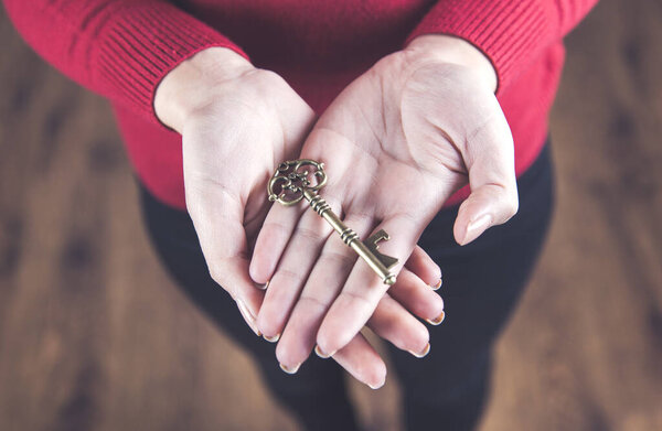 молодая женщина держит ключ в руке
