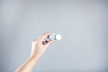 Gri arka planda kadın lensleri tutuyor