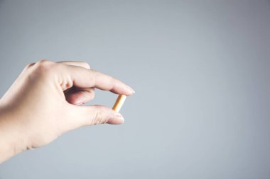 Kadın el hapları gri duvar arkasında