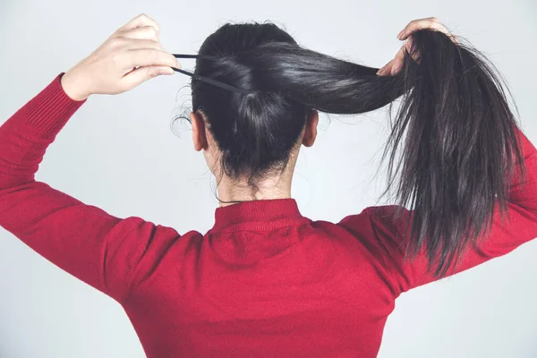 Mujer Mano Pelo Cola Sobre Fondo Gris —  Fotos de Stock