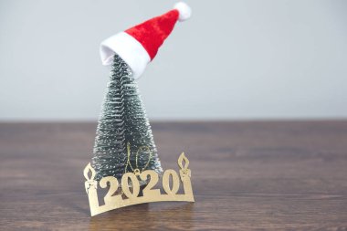 Noel şapkası ve Noel ağacı ahşap masada.