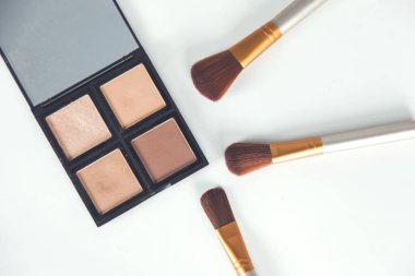 Beyaz masa arkasında makyaj aksesuarları