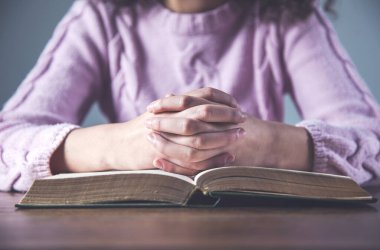 Dua eden kadın İncil 'i masaya uzattı.