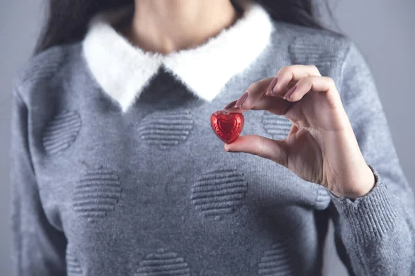 Młoda Kobieta Ręka Trzyma Cukierki Czerwone Serce — Zdjęcie stockowe