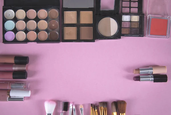 different makeup products on the pink background