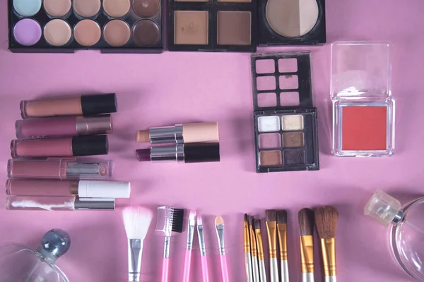 different makeup products on the pink background