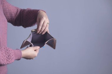 Gri arka planda kadın eli boş cüzdan